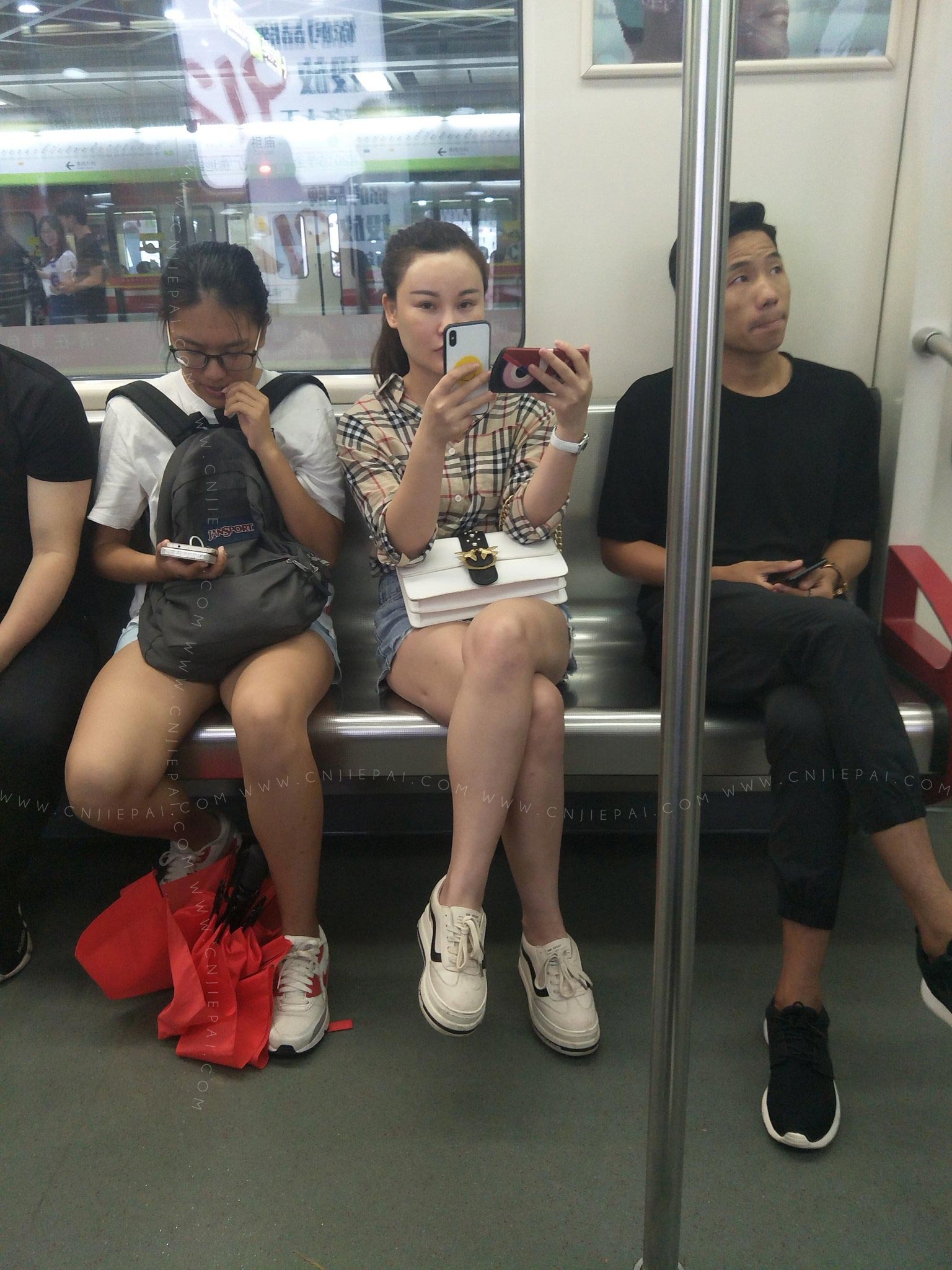 地铁上看手机的美女，脸有人工的痕迹 图2