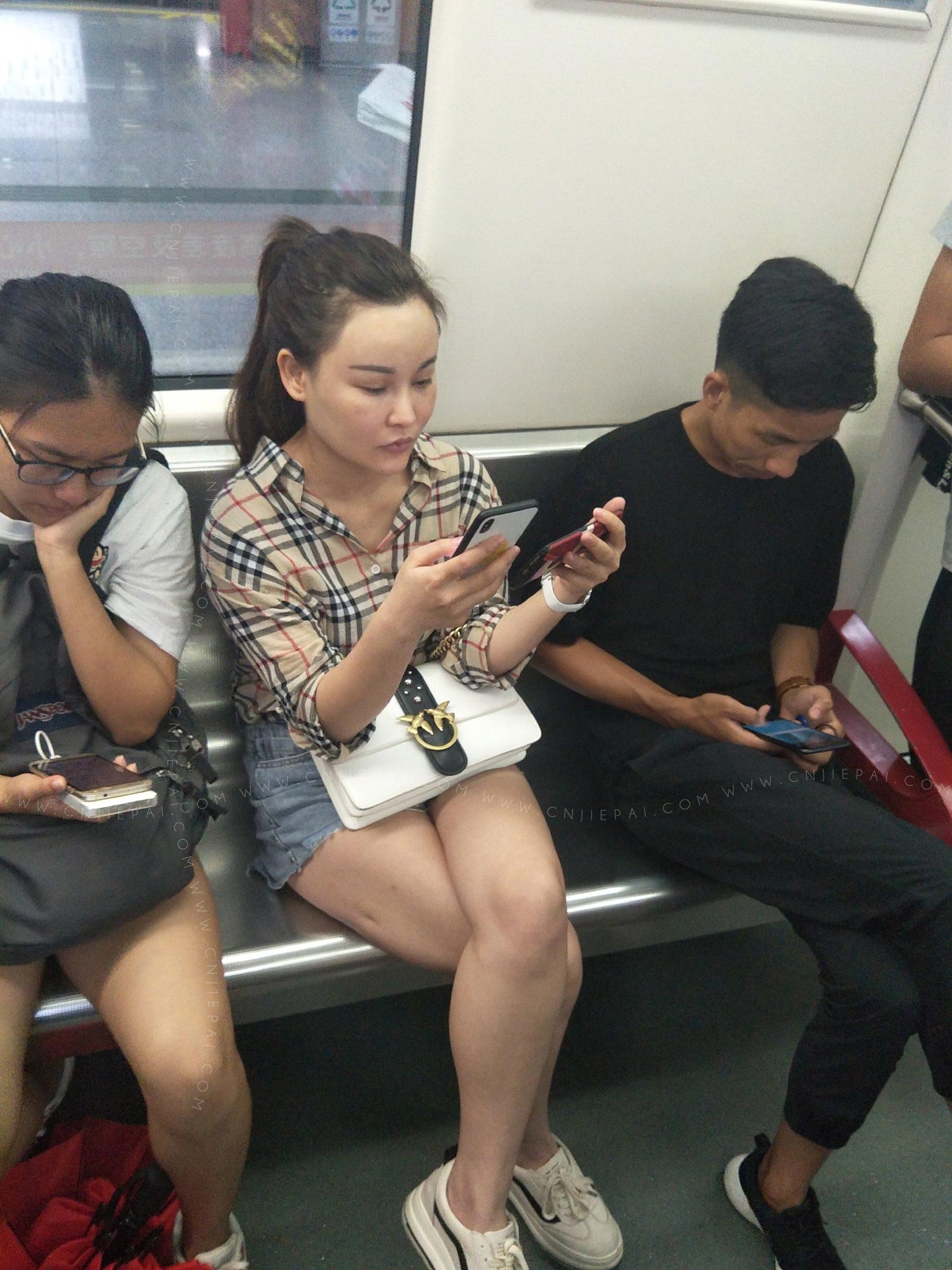 地铁上看手机的美女，脸有人工的痕迹 图3