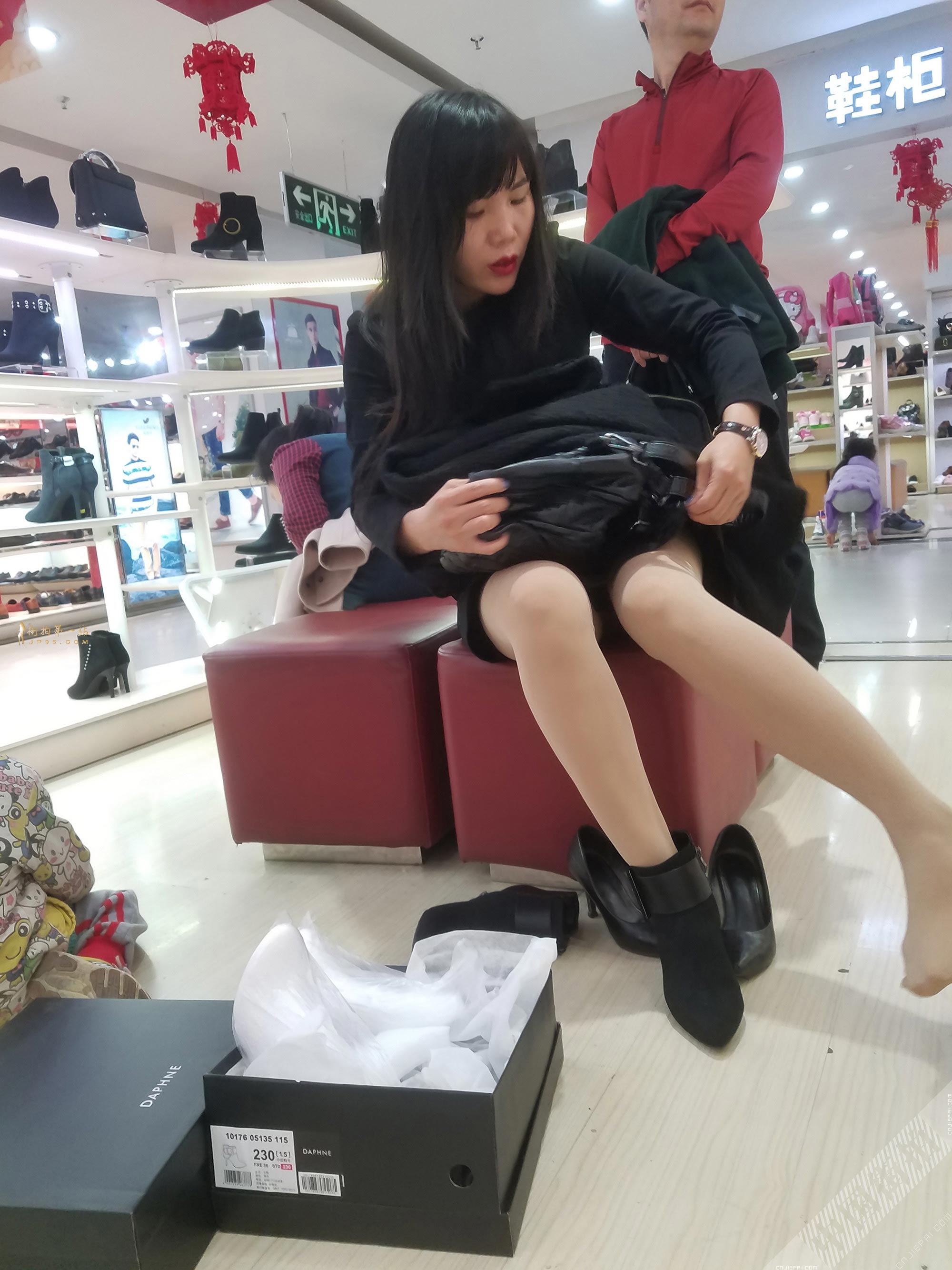 商场买鞋子的少妇，低头整理她脚上的丝袜 图1